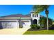 A home with a three-car garage, landscaped front yard and a stucco exterior is the main focal point of this photo at 4742 Balboa Park Loop, Bradenton, FL 34211