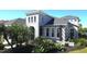 Beautiful home featuring a stucco exterior, arched entry, pergola and attractive landscaping with mature trees and plantings at 4742 Balboa Park Loop, Bradenton, FL 34211