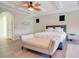 Stylish primary bedroom featuring tray ceilings, light hardwood floors, and a plush bed with a bench seat at 4742 Balboa Park Loop, Bradenton, FL 34211