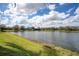 Scenic pond view with a lush green lawn under a partly cloudy sky at 4742 Balboa Park Loop, Bradenton, FL 34211