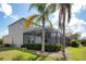 The rear exterior of the home featuring a screened-in patio, and a well-manicured backyard at 4742 Balboa Park Loop, Bradenton, FL 34211