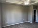 This bedroom has gray walls and carpet and a tray ceiling with fan for a modern look at 4802 51St W St # 1406, Bradenton, FL 34210