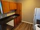 This kitchen features wood cabinets, black countertops, and modern appliances on a vinyl wood floor at 4802 51St W St # 1406, Bradenton, FL 34210