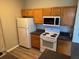 This kitchen features wooden cabinets, black counters, and white appliances, offering a cozy cooking space at 4802 51St W St # 1406, Bradenton, FL 34210