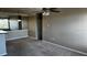 This living area has a ceiling fan, gray paint and carpet, with a partial view into the kitchen at 4802 51St W St # 1406, Bradenton, FL 34210