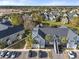 Aerial view of a community with a pond, featuring a building and surrounding houses at 5560 Rosehill Rd # 201, Sarasota, FL 34233