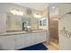 Modern bathroom with a double vanity, a large mirror, and a walk-in shower at 5830 Wake Forest Run # 102, Bradenton, FL 34211