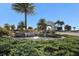 Landscaped entrance to community with water feature and palm trees at 5830 Wake Forest Run # 102, Bradenton, FL 34211