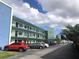 Multi-story condominium building with parking area and tropical landscaping at 5973 Terrace Park N Dr # 208, St Petersburg, FL 33709