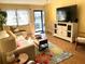 Bright living room with comfy seating and large TV at 5973 Terrace Park N Dr # 208, St Petersburg, FL 33709