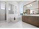 Bright bathroom with freestanding tub, separate shower, and elegant vanity with storage at 624 Blue Shell Loop, Sarasota, FL 34240