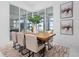 Bright dining room featuring large windows, modern decor, and beautiful wood table at 624 Blue Shell Loop, Sarasota, FL 34240