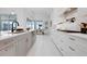 Contemporary kitchen with white cabinets, stainless steel appliances, and open view to dining area at 624 Blue Shell Loop, Sarasota, FL 34240