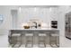 Bright white kitchen featuring an island with marble countertops and gold-legged stools at 624 Blue Shell Loop, Sarasota, FL 34240