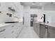 This kitchen features modern white cabinets, stainless steel appliances, and marble countertops at 624 Blue Shell Loop, Sarasota, FL 34240