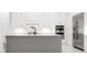 This kitchen features custom white cabinets, a gray island, and stainless steel appliances at 624 Blue Shell Loop, Sarasota, FL 34240