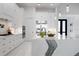 Stylish white kitchen with a large island, modern faucet, and stainless steel refrigerator at 624 Blue Shell Loop, Sarasota, FL 34240