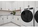 Contemporary laundry room with white cabinetry, granite countertops, and stainless steel appliances at 624 Blue Shell Loop, Sarasota, FL 34240
