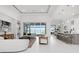Bright, open living area with modern furnishings, sleek tile flooring, and views of the pool and lake at 624 Blue Shell Loop, Sarasota, FL 34240