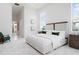 Bright main bedroom featuring neutral tones, tray ceilings, and natural light from a large window at 624 Blue Shell Loop, Sarasota, FL 34240
