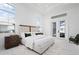Spacious and bright main bedroom with large bed, tray ceilings, and sliding doors to an outdoor patio at 624 Blue Shell Loop, Sarasota, FL 34240