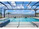 A stunning pool overlooking a scenic lake with a screened enclosure and beautiful blue skies at 624 Blue Shell Loop, Sarasota, FL 34240