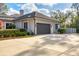 Attached garage with a modern door and landscaping at 6700 S Gator Creek Blvd, Sarasota, FL 34241