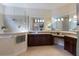 Modern bathroom featuring a walk-in shower, dual vanities, granite counters and tile flooring at 7115 Callander Cv, Lakewood Ranch, FL 34202
