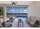 Screened lanai featuring cozy seating, a ceiling fan, and a relaxing view of the pool and the peaceful lake at 7115 Callander Cv, Lakewood Ranch, FL 34202