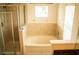 Well-lit bathroom showcasing a shower, large bathtub, and vanity with framed mirror at 731 Cristelle Jean Dr, Ruskin, FL 33570