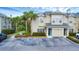 Tan two-story townhome with a teal door, two parking spots, and lush landscaping at 7664 Plantation Cir, Bradenton, FL 34201