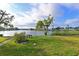 Scenic backyard with a paved walkway, bench, and tranquil lake views at 9514 Colonial Dr, Bradenton, FL 34210