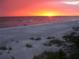 Scenic beach with walkers and a beautiful sunset, offering a tranquil coastal lifestyle at 9514 Colonial Dr, Bradenton, FL 34210