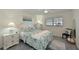 A serene bedroom featuring neutral walls, updated lighting, and a leafy-themed comforter at 9514 Colonial Dr, Bradenton, FL 34210