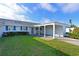 Charming home featuring a well-manicured lawn, blue shutters, and a convenient carport, offering classic curb appeal at 9514 Colonial Dr, Bradenton, FL 34210