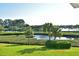 Beautiful view of lush green space with palm trees and a peaceful pond at 9514 Colonial Dr, Bradenton, FL 34210