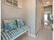 Inviting hallway with tiled floors, storage closets, and a coastal-themed bench creating a serene atmosphere at 9514 Colonial Dr, Bradenton, FL 34210