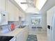 Bright kitchen featuring sleek white cabinets, tile backsplash, and modern appliances at 9514 Colonial Dr, Bradenton, FL 34210