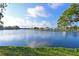 Picturesque lake view with houses in the background and trees surrounding at 9514 Colonial Dr, Bradenton, FL 34210
