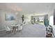 Bright and airy living room featuring scenic water views, a dining area, and neutral carpeting, perfect for entertaining at 9514 Colonial Dr, Bradenton, FL 34210