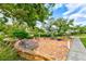 Brick patio with stone benches, surrounded by lush greenery and trees, creating a serene outdoor space at 9514 Colonial Dr, Bradenton, FL 34210