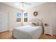 Bedroom with a double window and a light wood floor, decorated with wreath and a decorative pillow at 9623 Sea Turtle Ter # 201, Bradenton, FL 34212