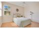 Bright bedroom features wood floors, decorative wreath above bed, and sunny window with shutters at 9623 Sea Turtle Ter # 201, Bradenton, FL 34212