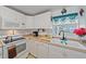 White kitchen with granite countertops and a sink at 1521 Graber Ave, Sarasota, FL 34239