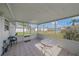 Relaxing screened porch with tiled floor, table, and chairs, offering a view of the backyard at 1521 Graber Ave, Sarasota, FL 34239