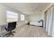 Bright bedroom with large windows, laminate flooring, and built-in workspace at 1777 Pomelo Dr, Venice, FL 34293