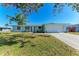 Ranch style home with light blue exterior, white garage door, and spacious lawn at 1777 Pomelo Dr, Venice, FL 34293