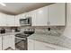 Modern kitchen with white cabinets, granite counters, and stainless appliances at 1777 Pomelo Dr, Venice, FL 34293