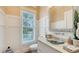 Powder room with glass vessel sink, white wainscoting, and a window at 178 N Washington Dr, Sarasota, FL 34236