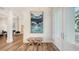 Bright and airy entryway with two-toned wood floors, white walls, and modern art at 178 N Washington Dr, Sarasota, FL 34236